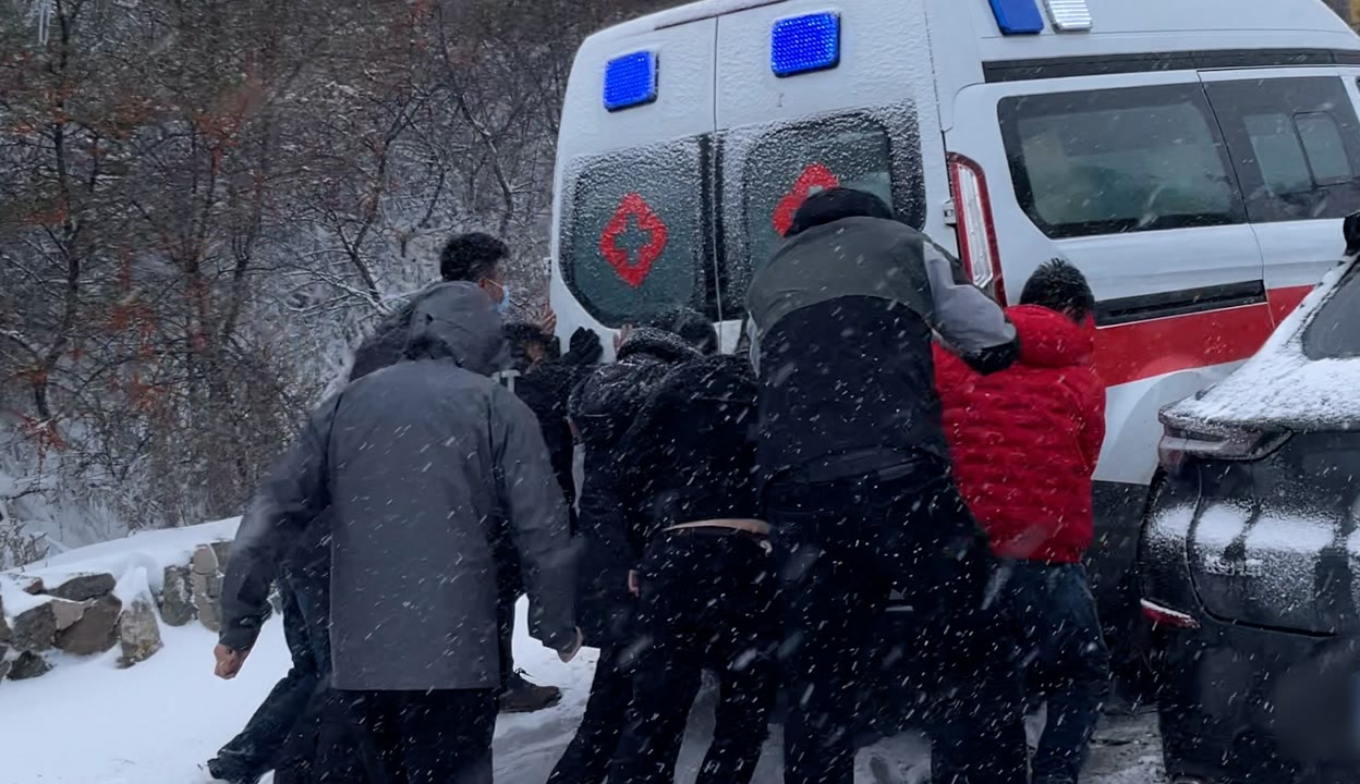 暖!河北豐寧一救護車雪地打滑被困 司機路人伸援手助其脫困